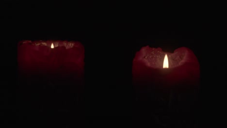 intimate close-up of two flickering candle flames in a dark, cozy setting. the soft, warm glow creates a serene mood, highlighting the flickers against the shadows in stunning detail