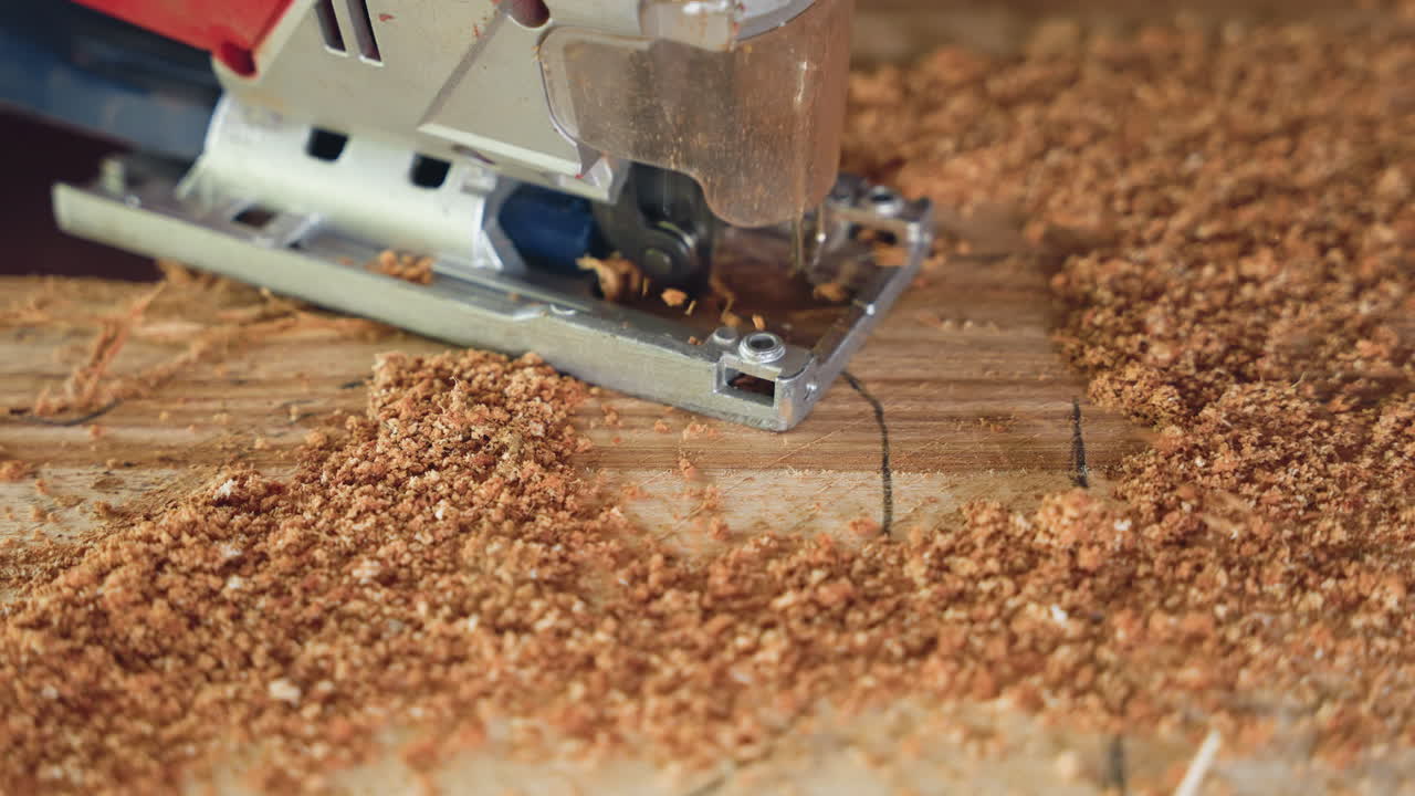 Closeup jigsaw cutting plywood surface, rich sawdust and focused blade movement, slow methodical carving across marked grain, tactile workshop atmosphere with warm wood tones and scattered shavings
