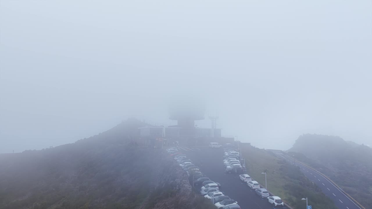 Parking lot and radar station covered by fog in Pico do Arieiro, Madeira Island, Portugal. Aerial