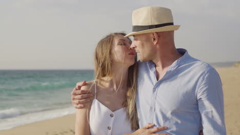 una pareja feliz besándose en una playa de arena