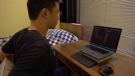 el programador se sienta frente a la computadora portátil con el código de estudio visual en la pantalla