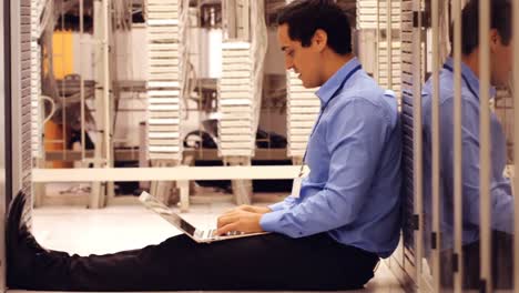 Technician-working-on-laptop-in-hallway