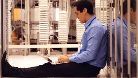 technician working on laptop in hallway