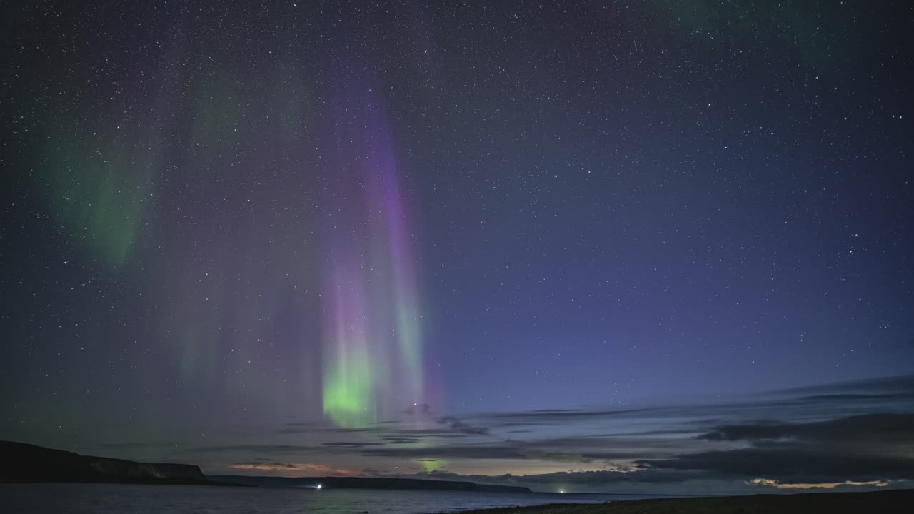 una magnífica exhibición de las luces del norte en el oscuro cielo de invierno sobre el tranquilo fiordo