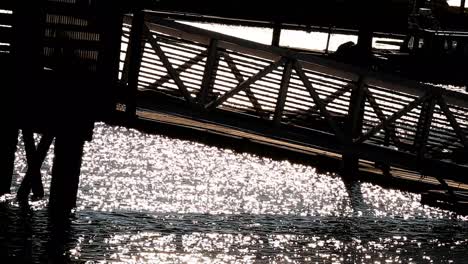 Side-view-of-walking-ramp-dock-over-shiny-water