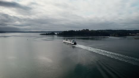 Hinter-Einer-Großen-Pendlerfähre-Auf-Dunklem,-Ruhigem-Wasser-Spiegeln-Sich-Düstere-Wolken,-Aus-Der-Luft