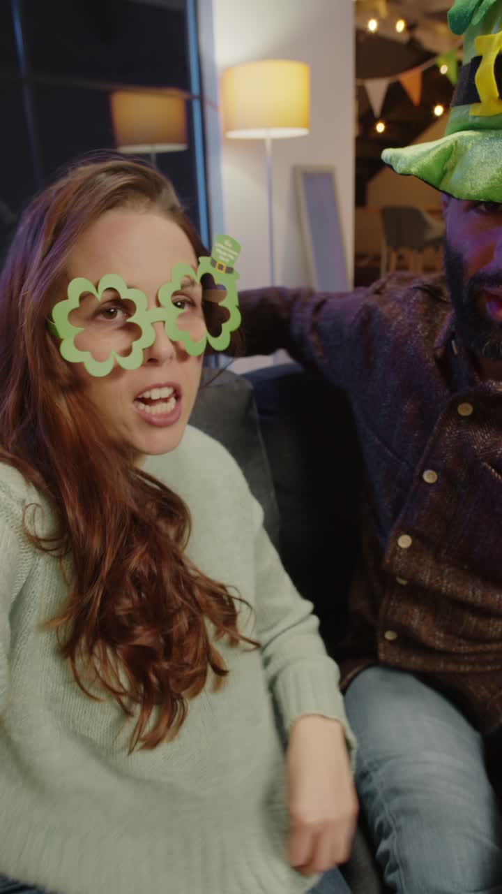 video vertical de amigos disfrazándose en casa o en un bar celebrando en la fiesta del día de san patricio posando para selfies en el teléfono en tiempo real 2