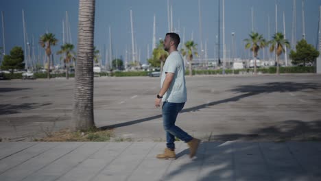 man walking and drinking coffee in a city park