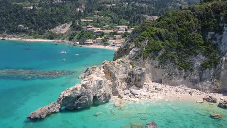 the holiday village of agios nikitas nestled behind seaside cliffs, with vegetation and rocks along the ionian sea shore, featuring an exotic beach