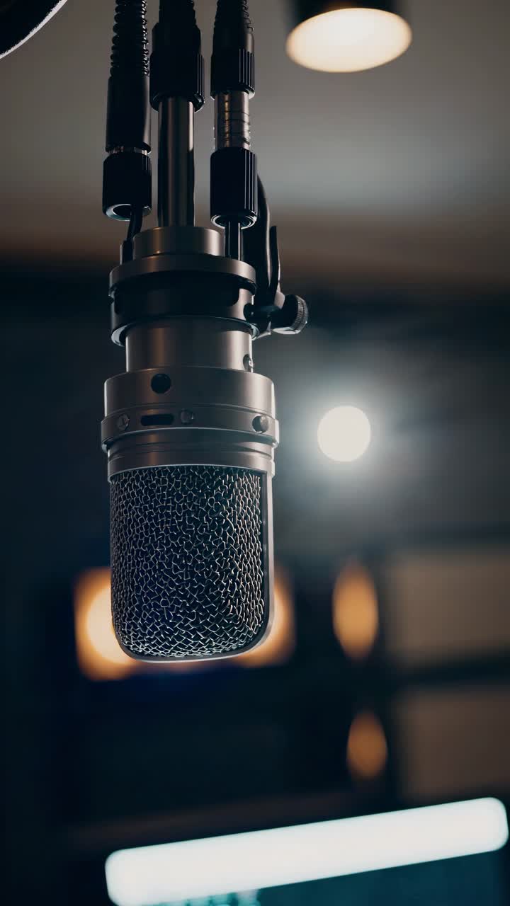 Close-up of a vintage microphone in a dimly lit studio, captured from a low angle, evoking a classic