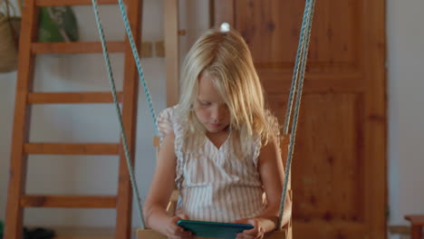 young girl using smartphone on indoor swing