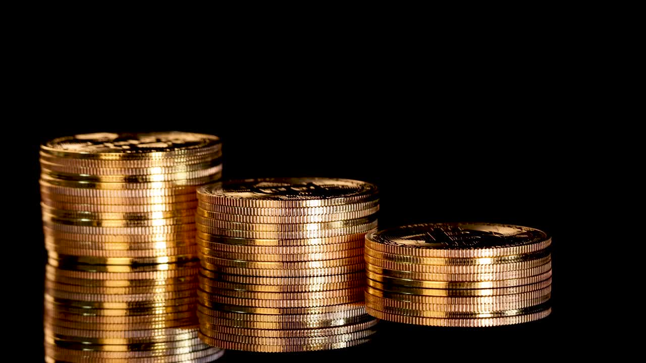 Gold coin stacks rotate smoothly under studio lighting, emphasizing metallic texture and digital currency symbolism