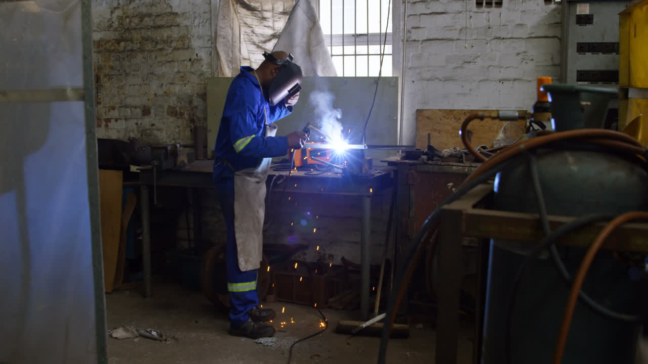 Metalsmith using welding torch in workshop 4k