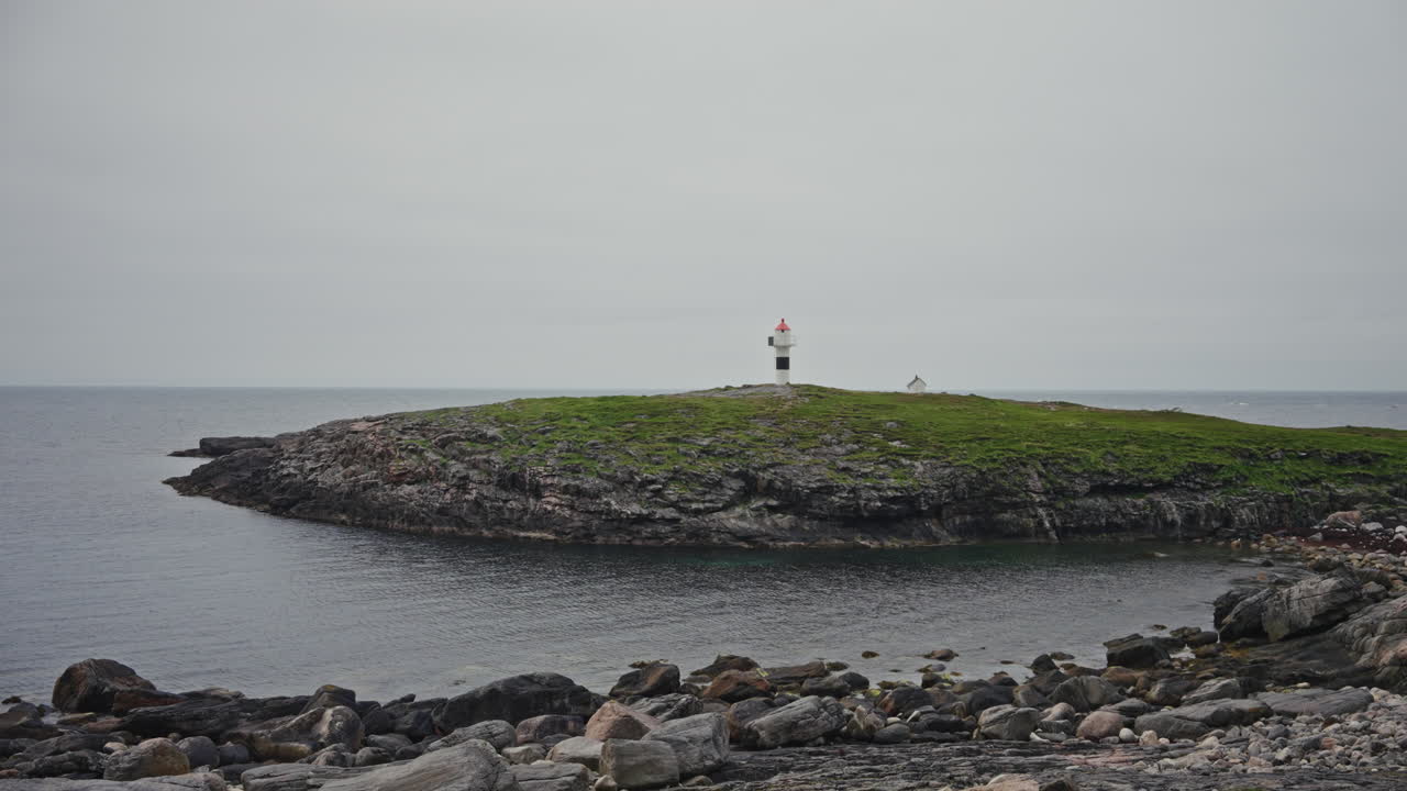 Panoramic view of the rugged rocky coastline in the Lofoten Isands, Norway. View of a small lighthouse overlooking the coastline.