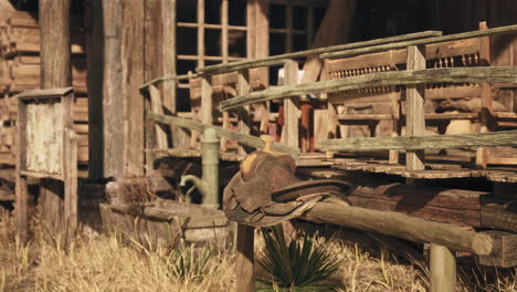 an old western saddle sitting outside of a rustic building