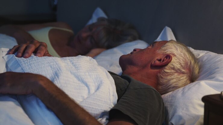 Zorgwekkende oudere man in bed's nachts lijdt aan slapeloosheid