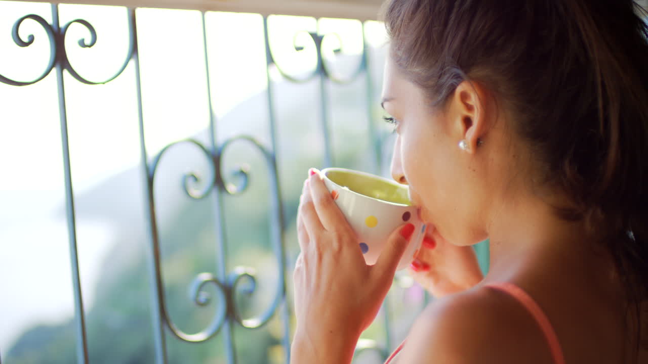 발코니 에서 술 을 마시는 여자