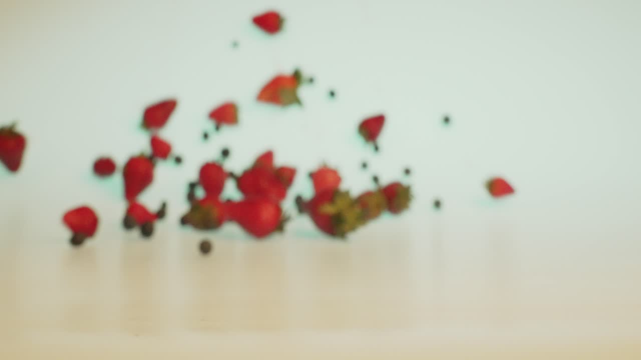 신선하고 즙이 많은 딸기와 딸기가 테이블에 떨어지고 카메라를 향해 굴러가는 창의적인 과일 컨셉 샷