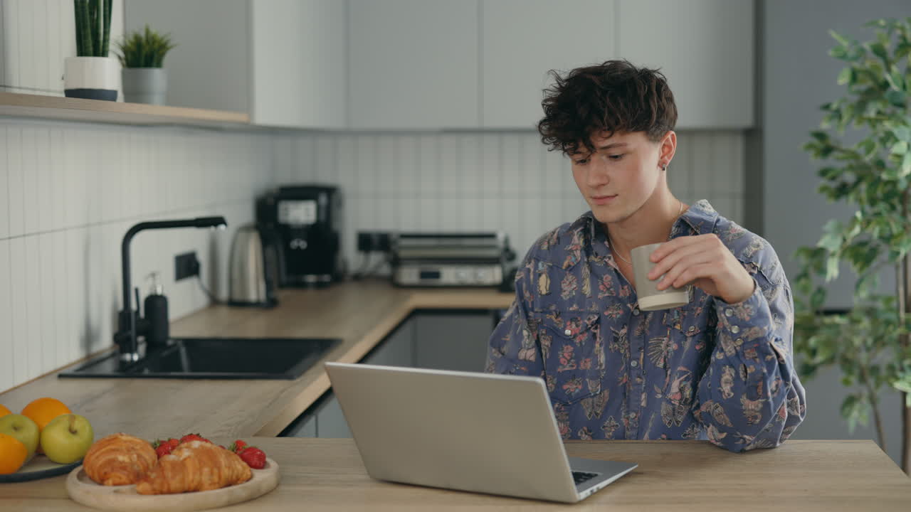 Young man working from home in kitchen