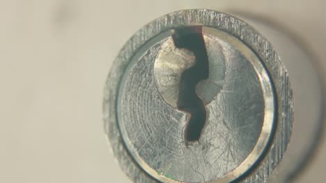 macro tilt up video of a keyhole, silver door lock