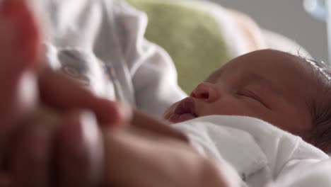 close up of parents cuddling newborn baby son in nursery