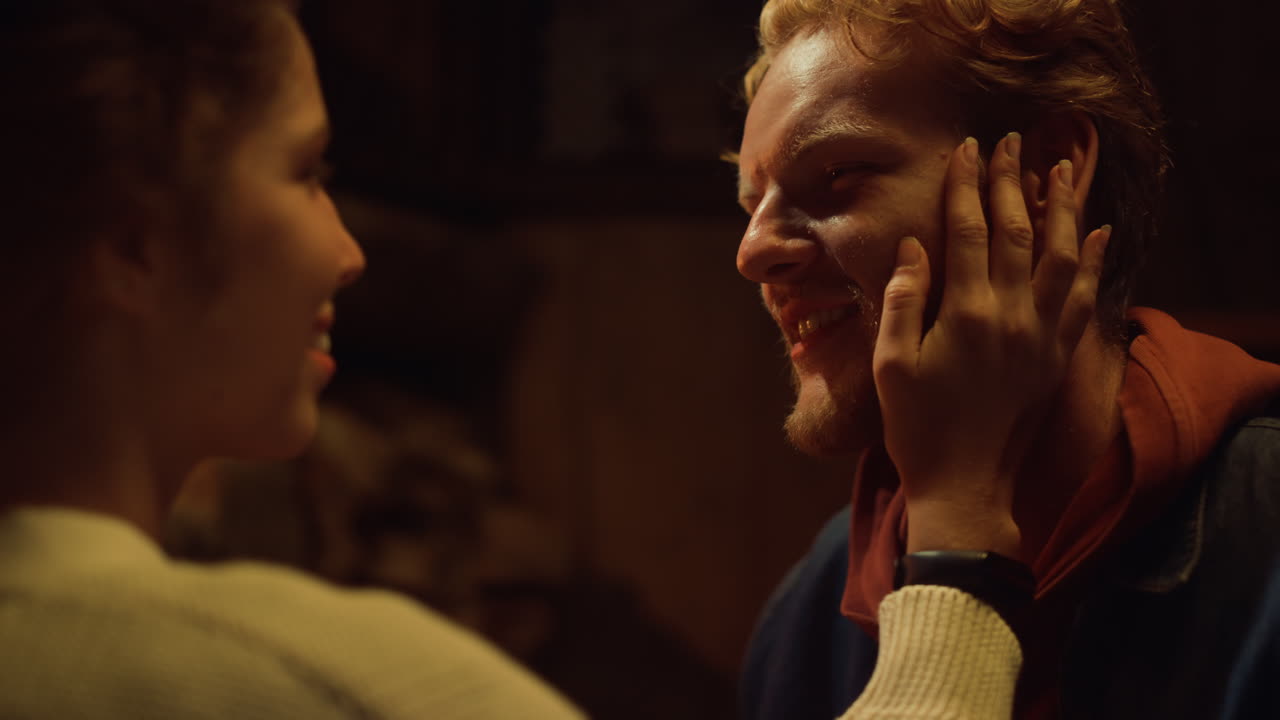 Due amanti si godono la compagnia l'uno dell'altro davanti al caminetto. Una coppia romantica si tocca il viso durante un appuntamento.