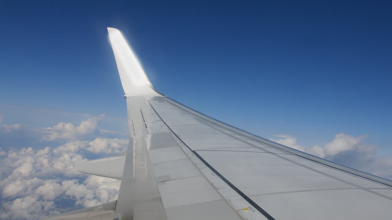 крыло пассажирского авиалайнера, летящее над облаками