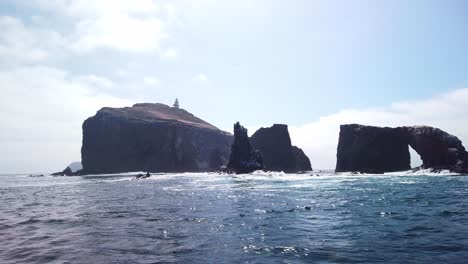 Close-up-gimbal-shot-from-a-moving-boat-traveling-around-the-famous-Arch-Rock-at-East-Anacapa-Island-in-Channel-Islands-National-Park,-California