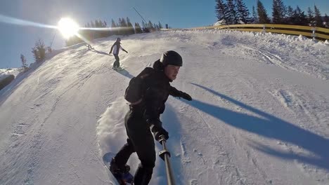 front action cam view of snowboarder going down the mountain in slow motion on a clear day