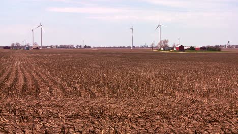 Riesige-Windmühlen-In-Der-Ferne-Erzeugen-Strom-Hinter-Farmen-Im-Mittleren-Westen-Der-USA