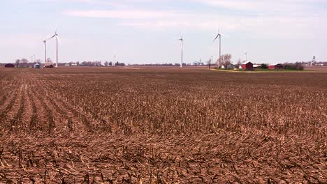 molinos de viento gigantes en la distancia generan energía detrás de las granjas en el medio oeste americano