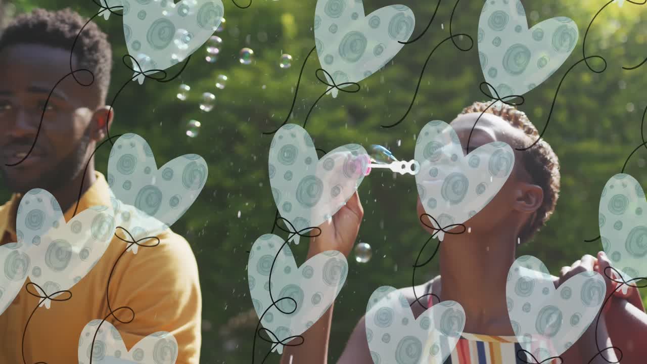 Animatin of heart balloons over happy african american family making soap bubbles in garden