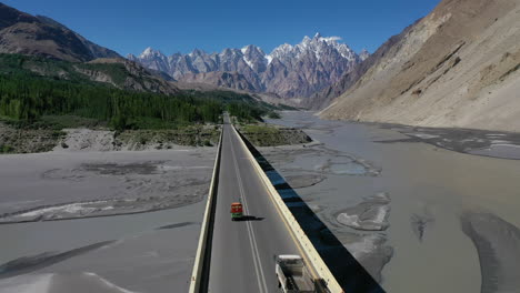 vista aérea siguiendo un auto rickshaw cruzando un puente en las pintorescas montañas del valle de hunza
