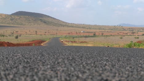 Eine-Masai-frau-Mit-Einem-Sonnenschirm-Spaziert-Unter-Der-Heißen-Afrikanischen-Sonne-In-Kenia-Oder-Tansania-1