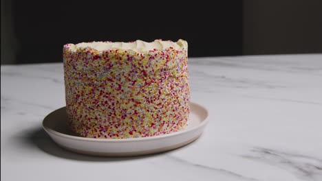 studio shot of birthday cake covered with hundreds and thousands decorations 10