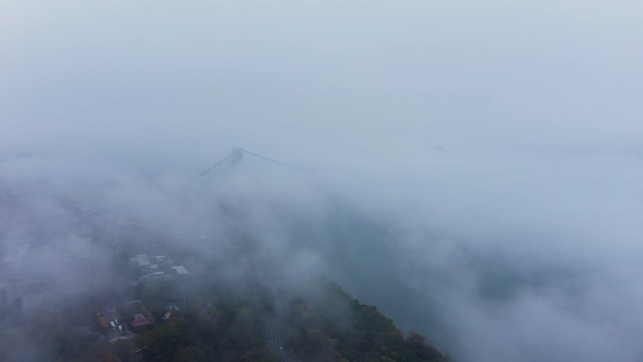 slow aerial descent through the clouds in New York City with the George Washington Bridge in the distance just peeking out