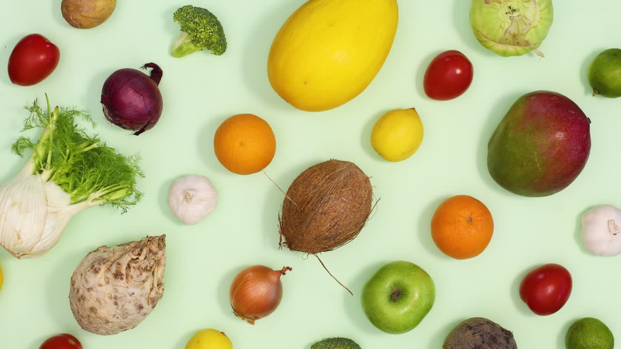 el patrón creativo hecho de frutas y verduras aparece en un fondo verde claro.