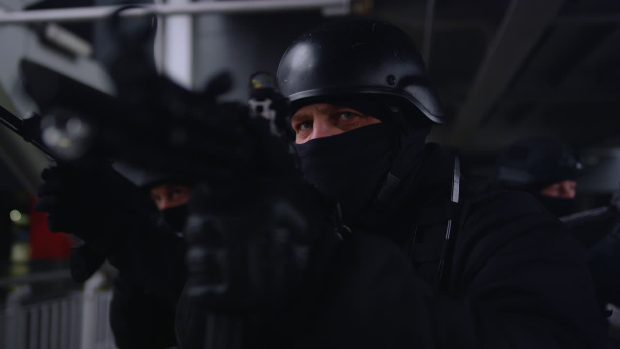 grupo de fuerzas especiales con cascos apuntando al objetivo con rifles de asalto en operación