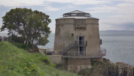 Establishing-side-view-of-Howth-Martello-Tower-Sutton-Ireland,-handheld-static