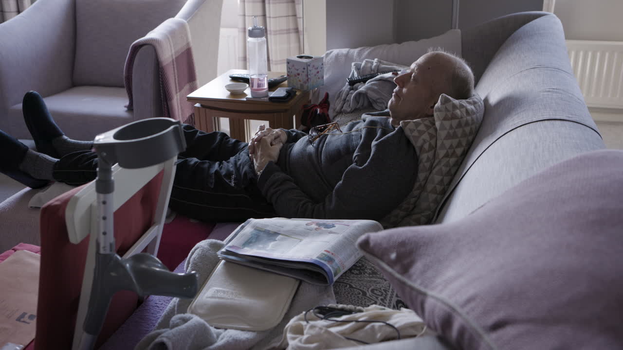 Elderly man resting on a couch at home
