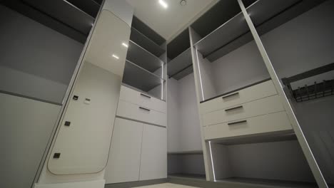 spacious walk-in closet features sleek grey cabinetry with integrated led lighting, offering a sophisticated and functional clothing storage solution