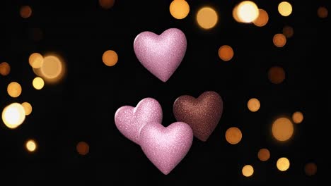 pink and brown glitter hearts on black background