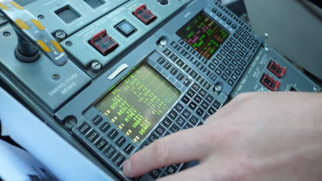 pilot hand using flight management system in the cockpit, fms