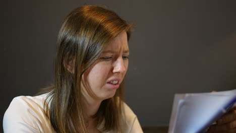 sad upset woman in debt looking at bills and paperwork