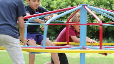 children at playground with carousel spinning round