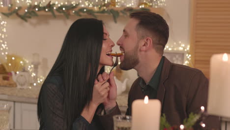 happy couple sharing a potato chip during christmas dinner