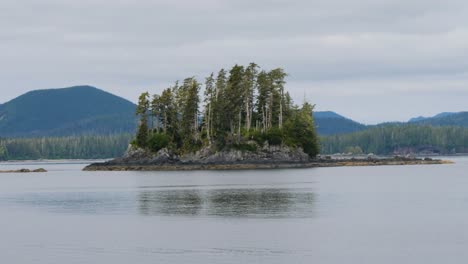 sailing around sitka, alaska.small rocky island covered with pine trees.