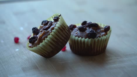 two fresh baked muffins with cranberries falling on top out the oven vegan pumpkin muffins using real roasted pumpkin in bowl healthy dairy-free recipe vegan