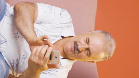 vídeo vertical de un anciano feliz enviando mensajes de texto por teléfono. sonriendo.