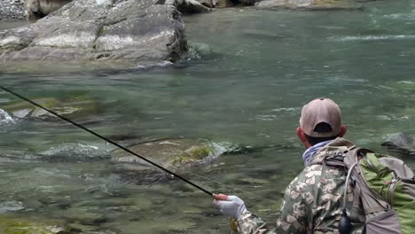 trout fly fishing in mountain river at summer